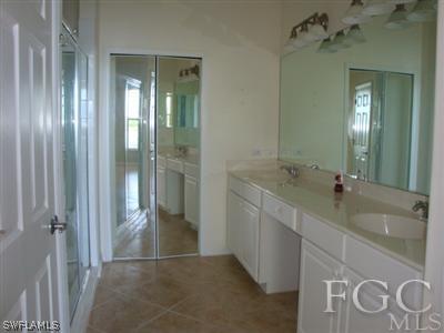 2623 Somerville Loop, Unit 508 Cape Coral, FL 33991 - Photo 9 of 10 a bathroom with a double vanity sink and mirror