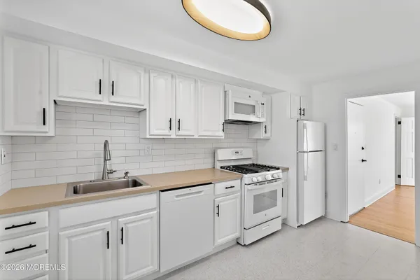 a kitchen with white cabinets and a stove