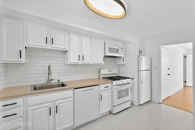 a kitchen with white cabinets and a stove