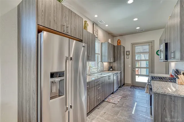 a kitchen with stainless steel appliances granite countertop a refrigerator and a stove