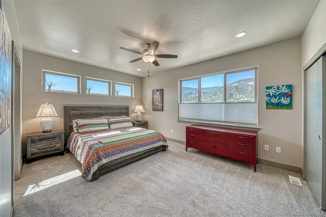 a spacious bedroom with a bed and a chandelier