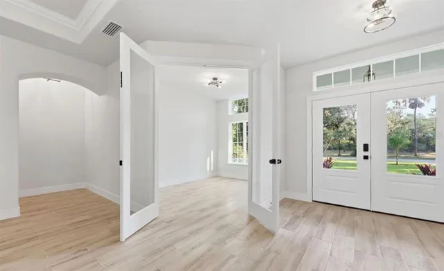 an empty room with wooden floor and windows