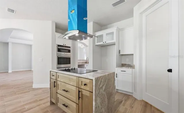 a kitchen with stainless steel appliances granite countertop a stove a sink and a wooden floors