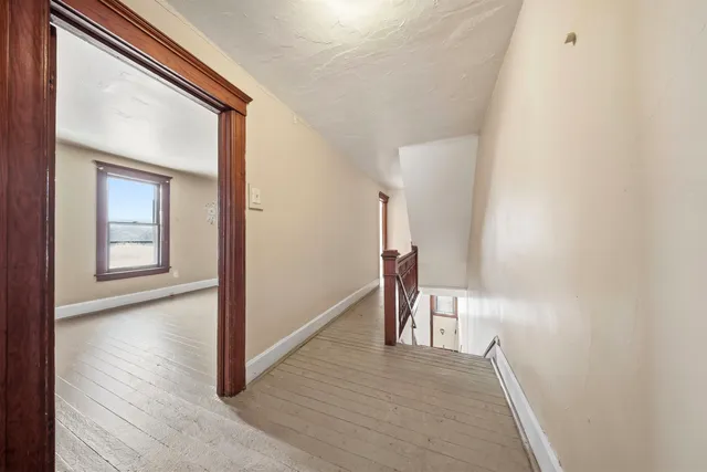 a view of a hallway with wooden floor and a hallway