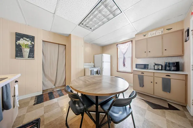 a kitchen with stainless steel appliances granite countertop a table chairs and a refrigerator