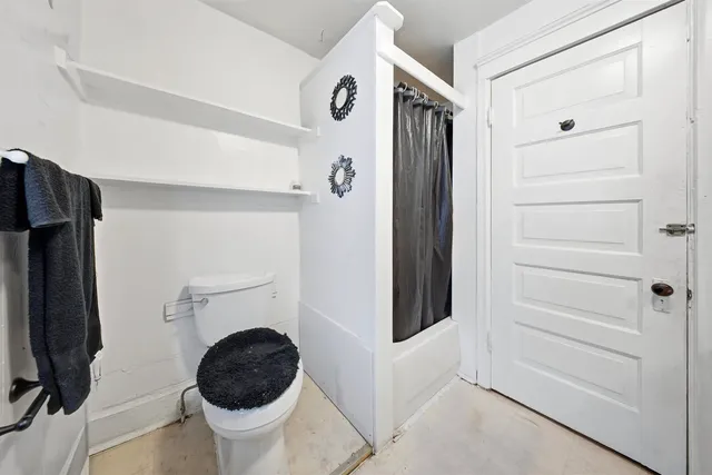a bathroom with a toilet and a shower
