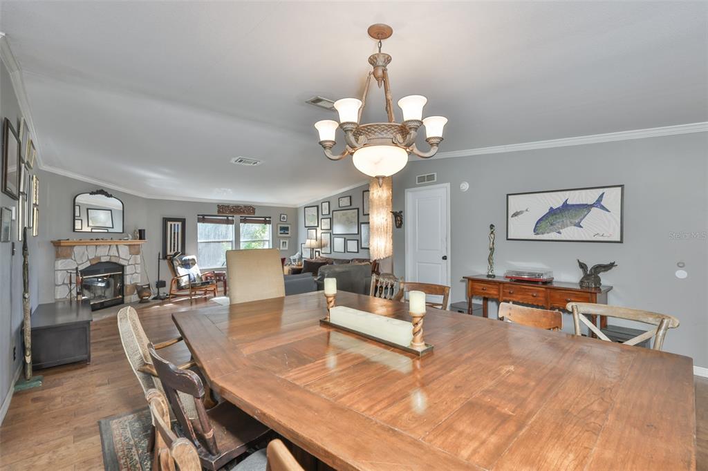 20112 Hobbs Road Wimauma, FL 33598 - Photo 16 of 94 a living room with fireplace chandelier furniture and view of kitchen