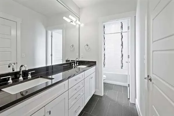 a bathroom with a double vanity sink and mirror with shower