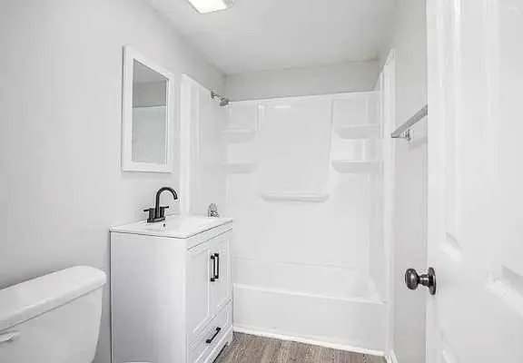 a bathroom with a sink a toilet and shower