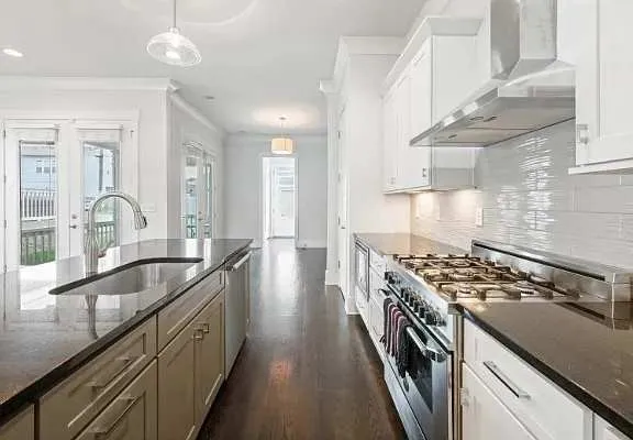 a kitchen with granite countertop a stove and a sink