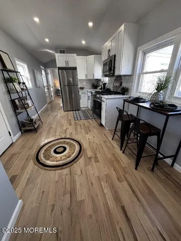 a kitchen with a table chairs refrigerator and microwave