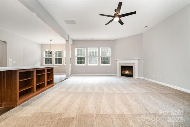 a view of an empty room with a window and a fireplace