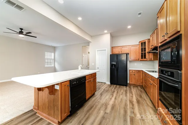 a large kitchen with stainless steel appliances a stove a refrigerator and a sink