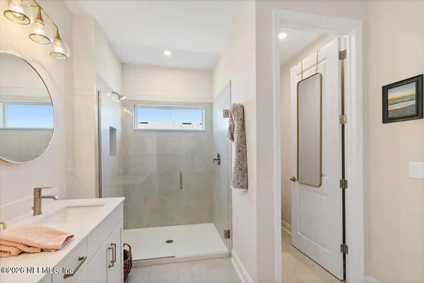 a bathroom with a granite countertop sink a mirror a vanity and shower