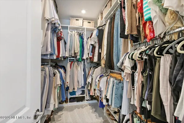 a view of walk in closet with clothes