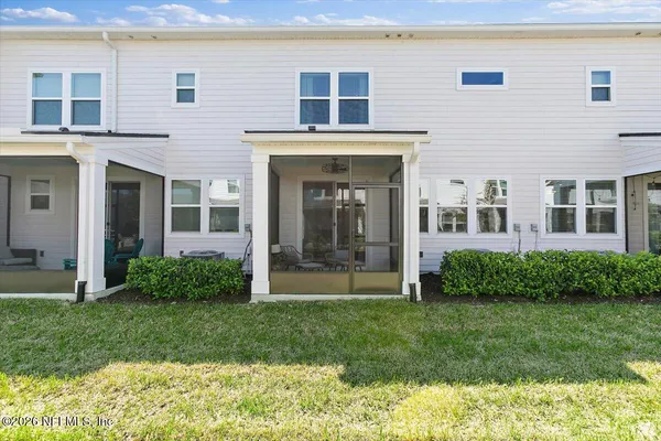 a view of front of a brick house with a yard