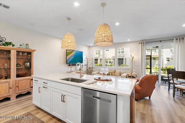 a kitchen with stainless steel appliances granite countertop a sink a stove and a wooden floors