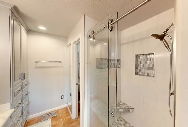 a bathroom with a shower and a glass door