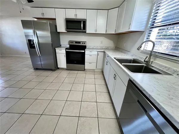 a kitchen with stainless steel appliances granite countertop a sink a stove a microwave and a refrigerator