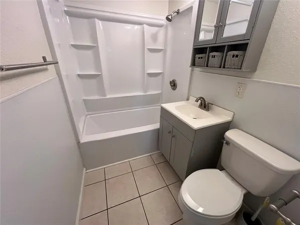 a kitchen with stainless steel appliances granite countertop a sink a stove a refrigerator a washer dryer and white cabinets