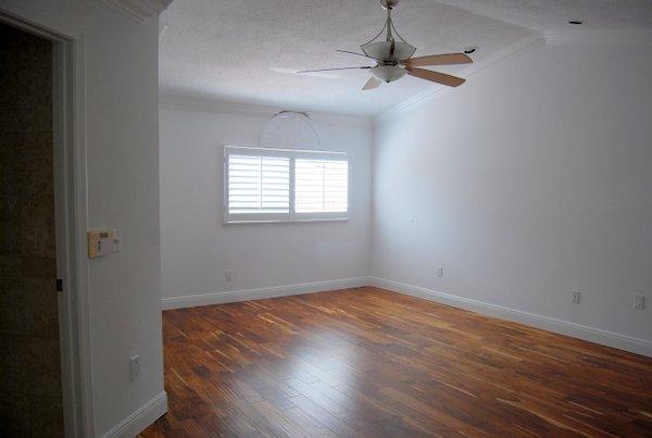 10473 Lake Vista Circle Boca Raton, FL 33498 - Photo 22 of 22 an empty room with wooden floor chandelier fan and windows