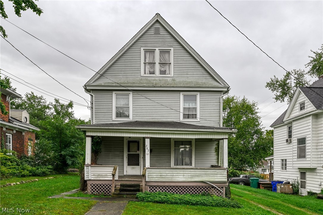 267 West Riddle Avenue Ravenna, OH 44266 - Photo 24 of 47 Classic Colonial-style residence featuring a steeply pitched gable roof with a dormer window, horizontal vinyl siding exterior, and a covered front porch with lattice detailing
