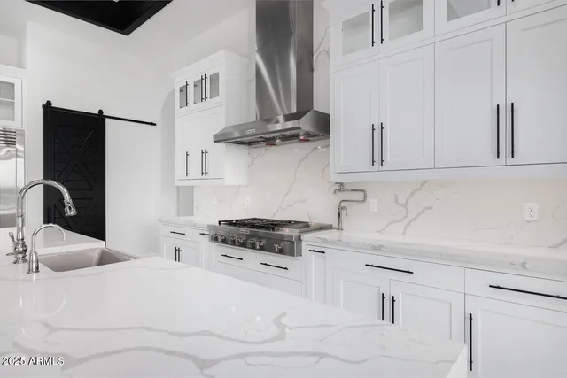 a kitchen with stainless steel appliances granite countertop a sink a stove and cabinets