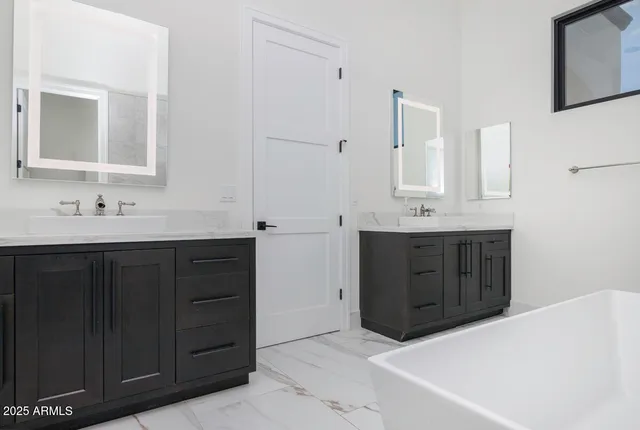 a bathroom with a tub sink and mirror