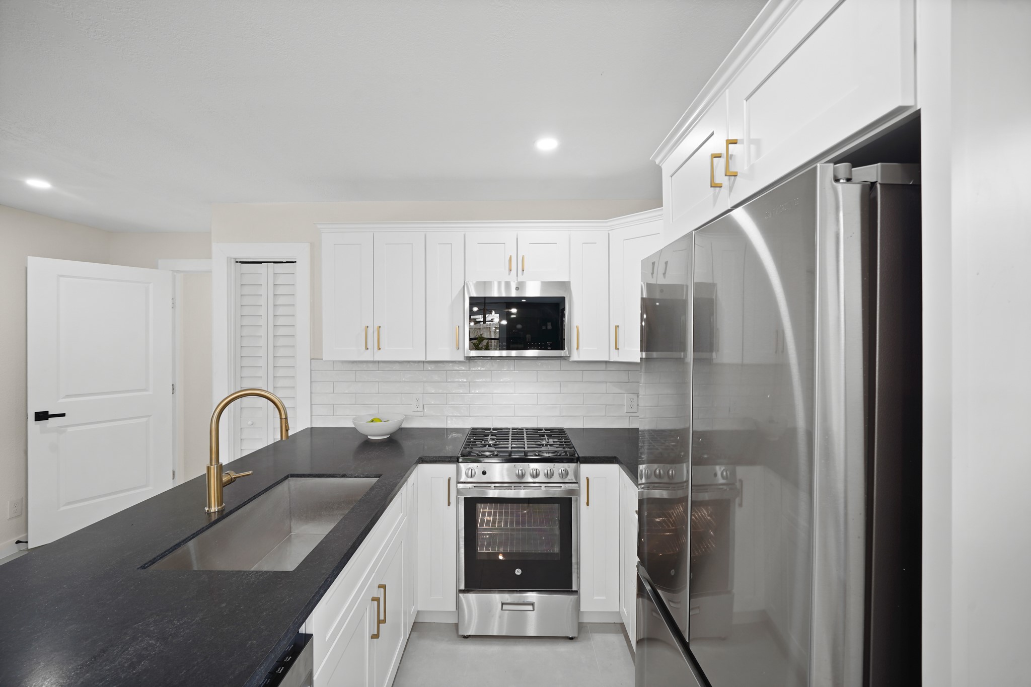 4813 Hummingbird Street Houston, TX 77035 - Photo 25 of 50 Preparing Meals is a Breeze on this G.E. 4 Burner Stainless Steel Gas Range with Oven Below and the Built in Stainless Steel G.E. Microwave. The Kitchen also offers Additional Storage in the Shelved Pantry.