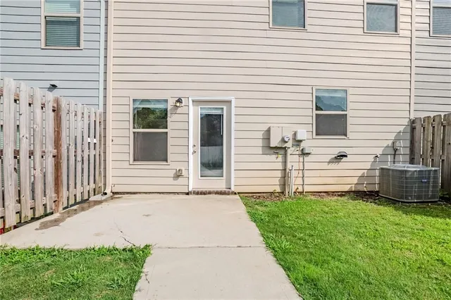 a view of a white house with a yard and large tree