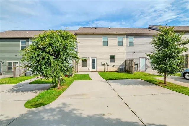 a view of a white house with a yard and plants