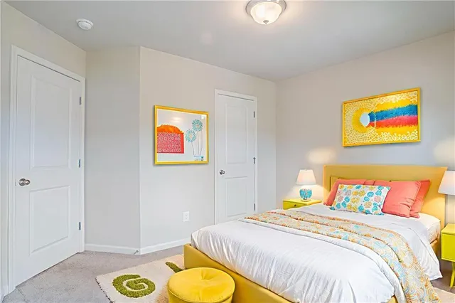 a bedroom with a bed and painting on the wall