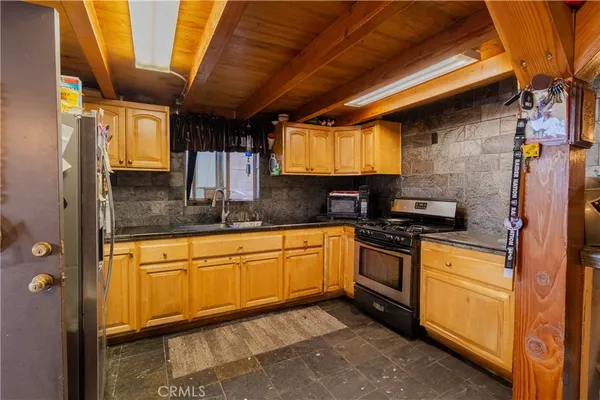 a kitchen with stainless steel appliances granite countertop a sink a stove and a refrigerator