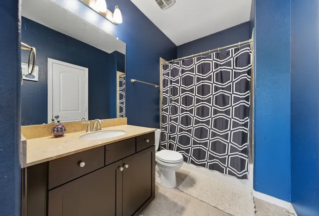 a bathroom with a double vanity sink mirror and toilet