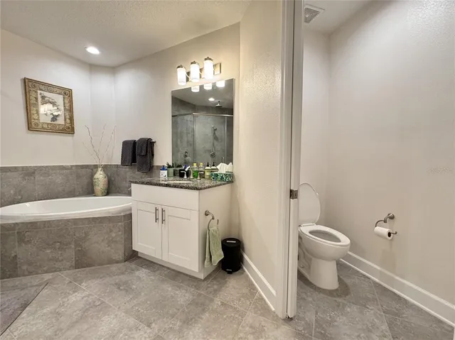 a spacious bathroom with a toilet a sink and a mirror