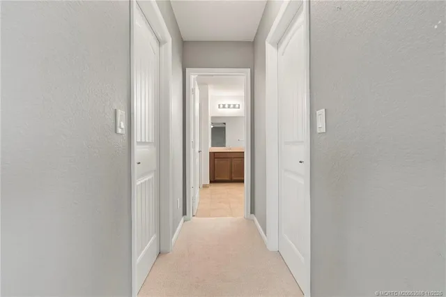 a view of a hallway with a white walls and a bathroom