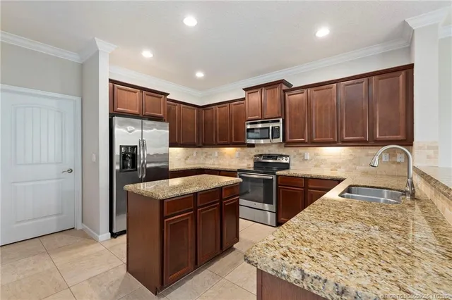 a kitchen with stainless steel appliances granite countertop a stove top oven a sink and dishwasher