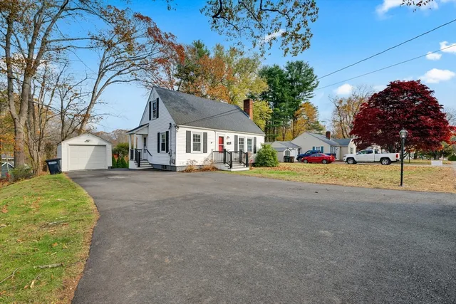 a view of road with house and trees in the background