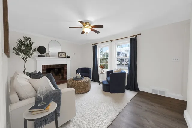 a living room with furniture a fireplace and a large window