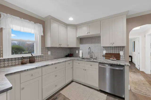 a kitchen with granite countertop white cabinets and white appliances