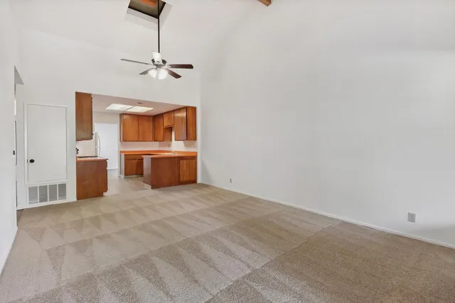 a big room with chandelier fan and a bed