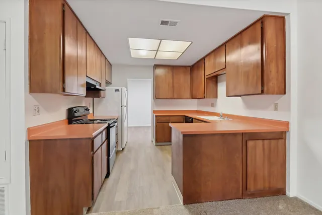 a kitchen with stainless steel appliances granite countertop a sink a stove and a refrigerator