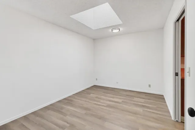 an empty room with wooden floor and entrance