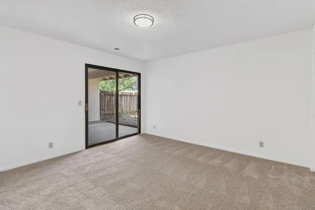 an empty room with wooden floor & closet and windows