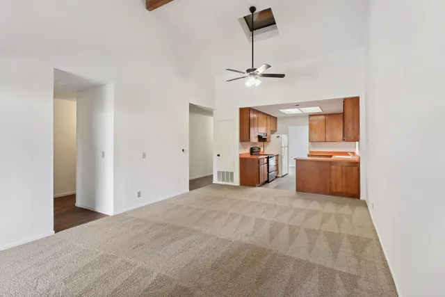 a view of a livingroom with furniture nad kitchen appliances