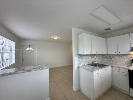 a kitchen with granite countertop white cabinets and white appliances
