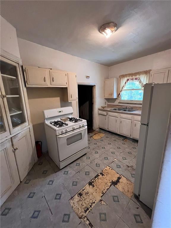 235 Marion Street McKees Rocks, PA 15136 - Photo 4 of 8 a kitchen with a stove a refrigerator and a sink
