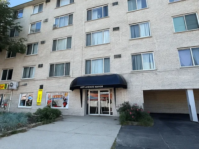 a front view of a brick house with many windows and yard
