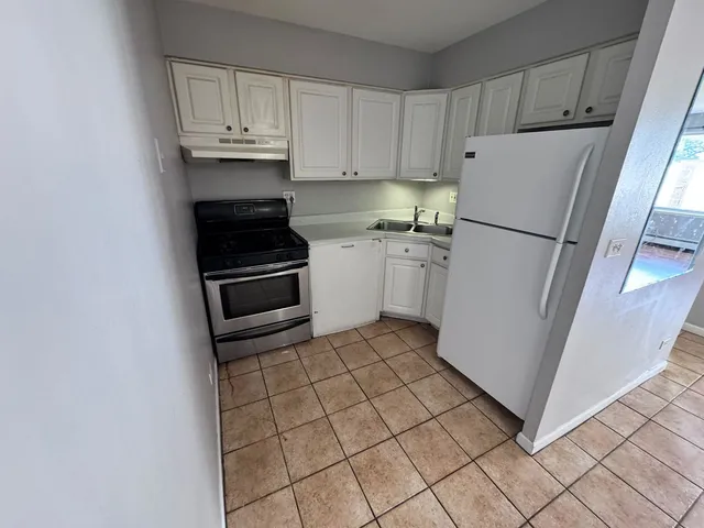 a kitchen with a refrigerator sink and cabinets