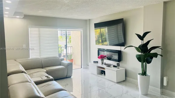 a living room with furniture and floor to ceiling window